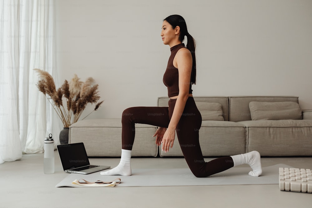 a woman in a brown top and leggings doing yoga