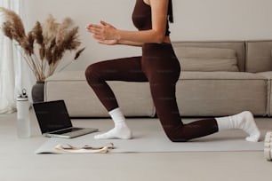a woman in a brown outfit is doing yoga