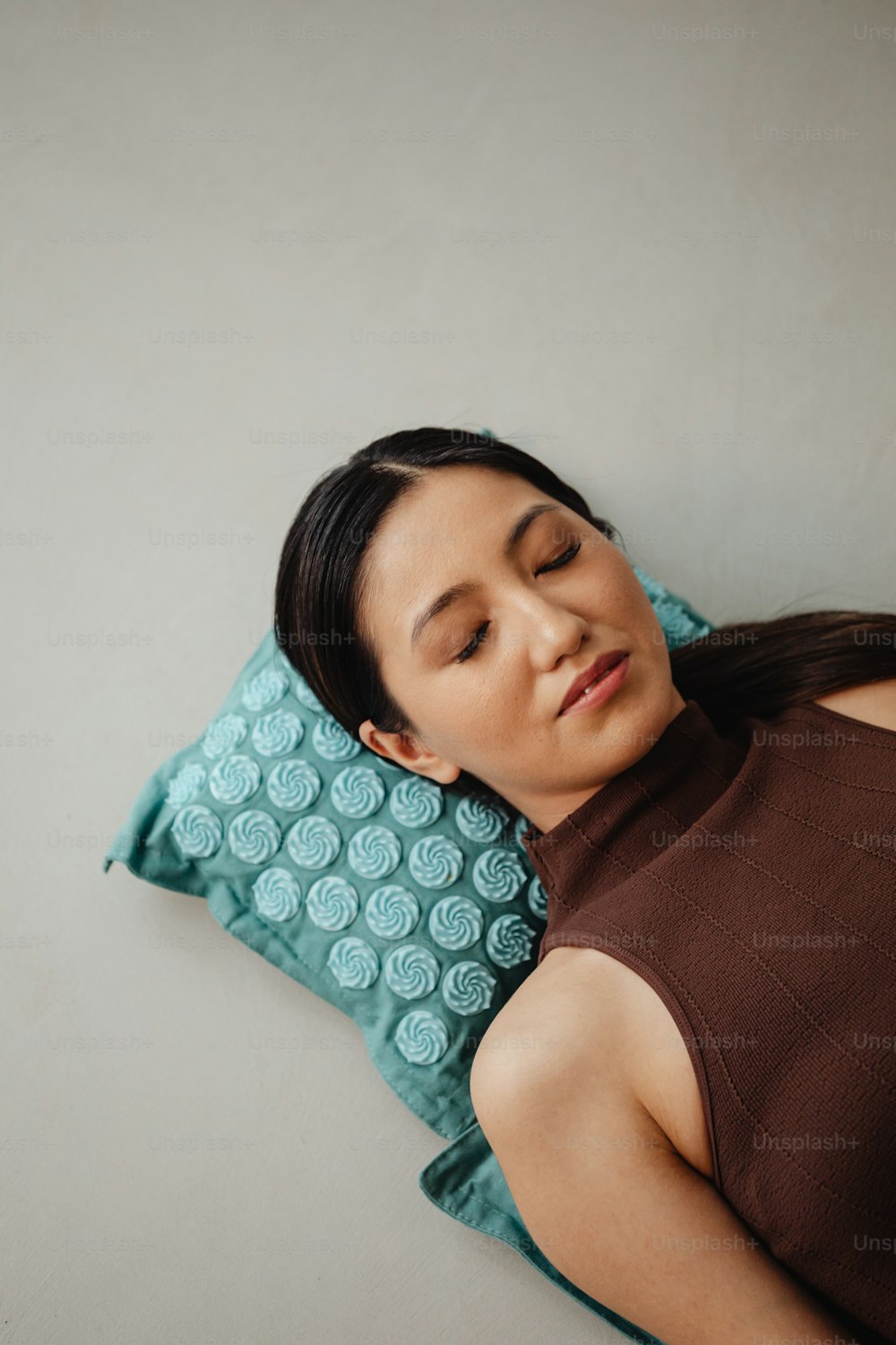 a woman laying on a pillow with her eyes closed