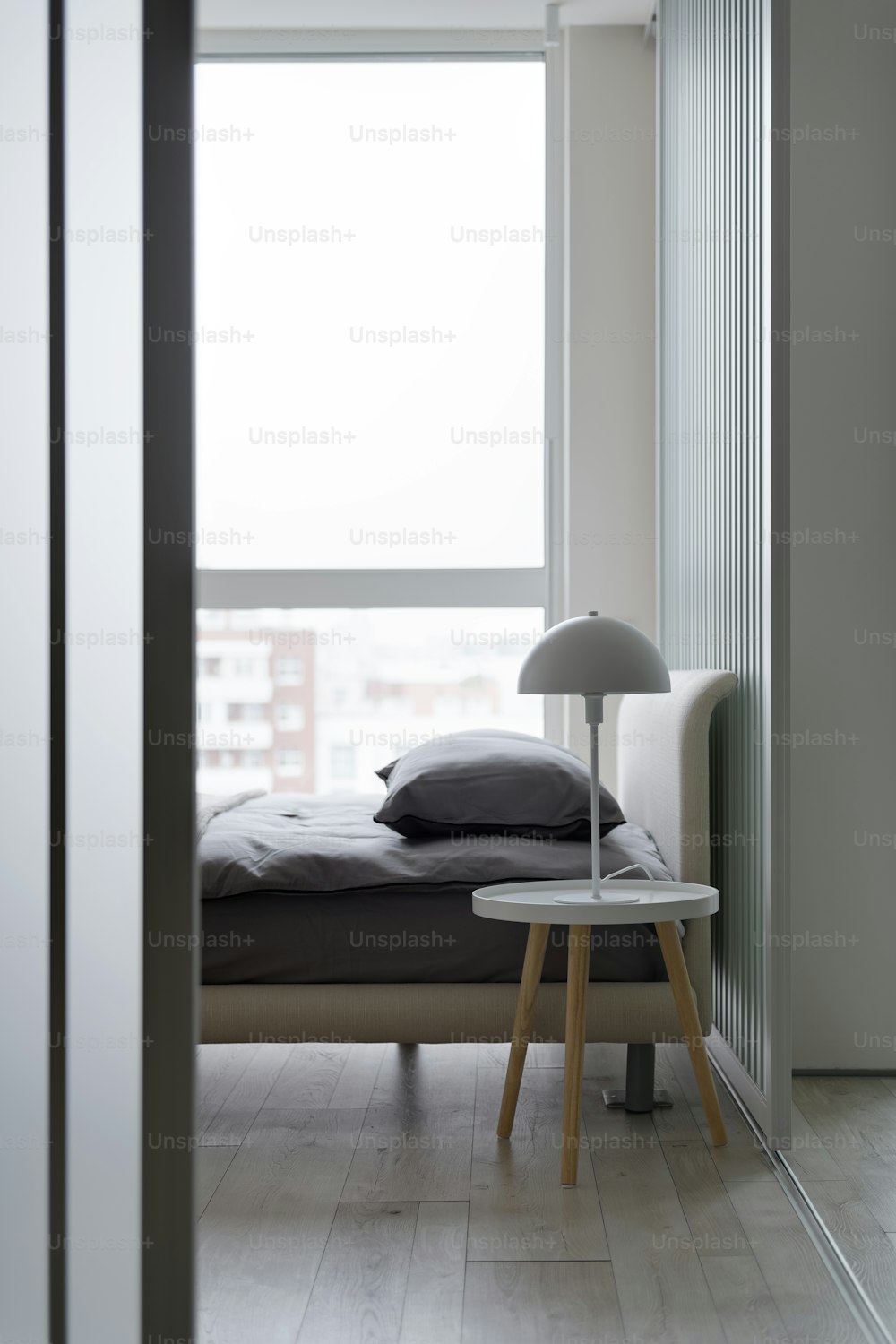 un lit assis à côté d’une fenêtre dans une chambre