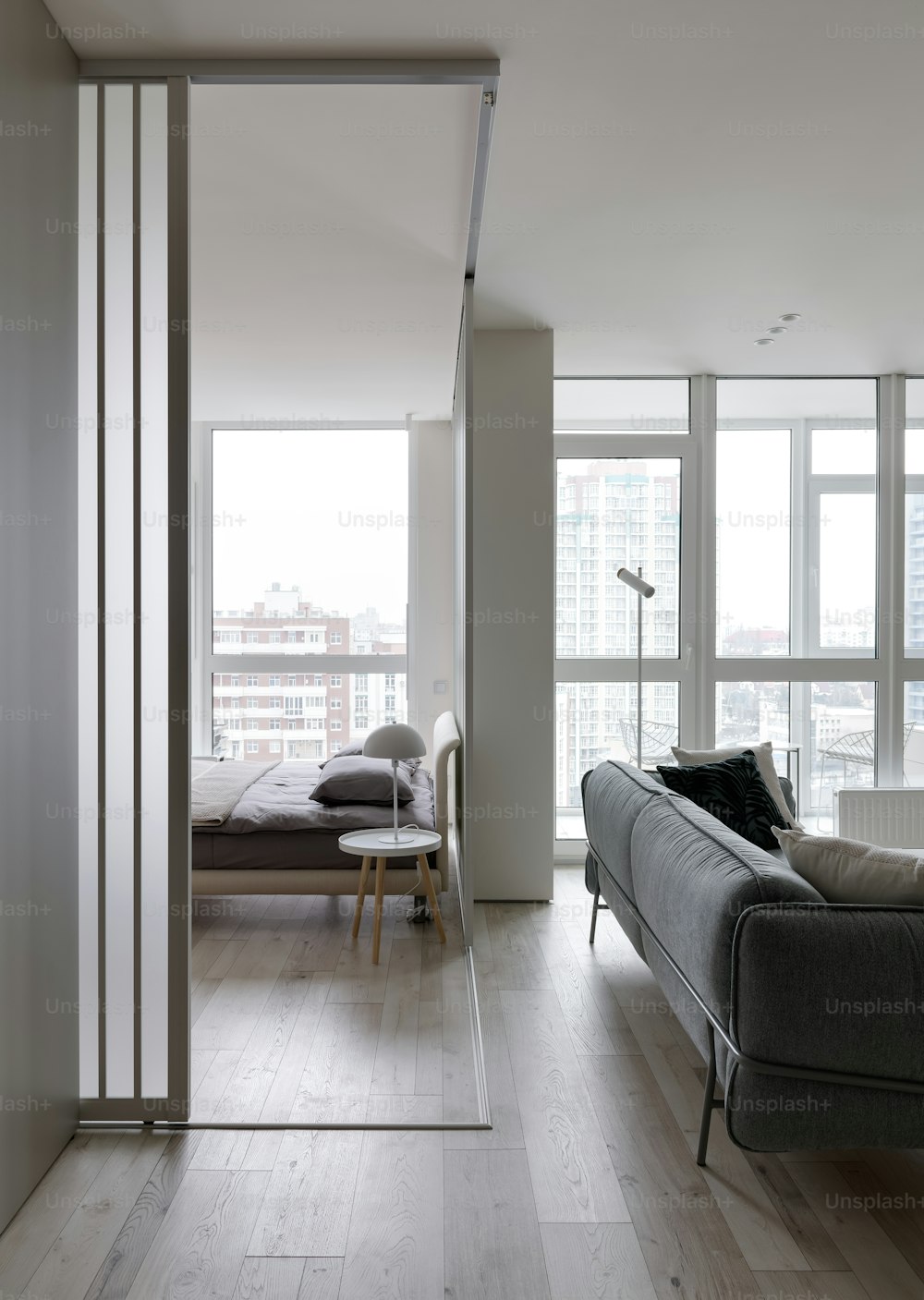 a living room filled with furniture and large windows