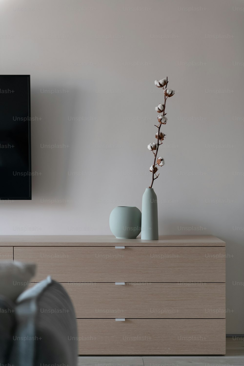 a vase with flowers is sitting on a dresser