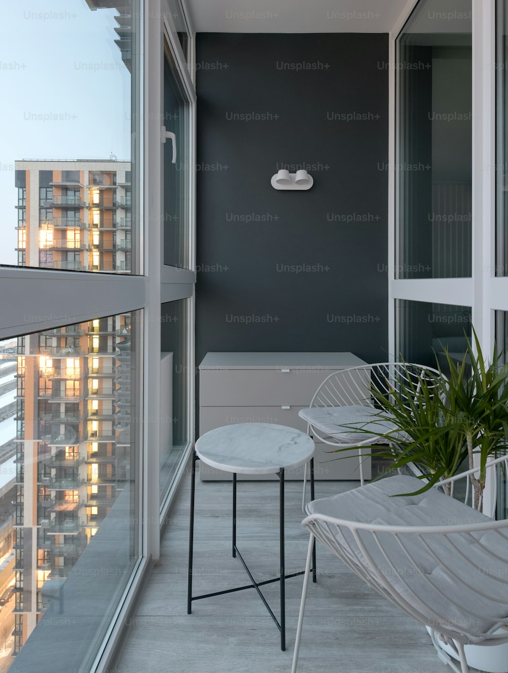un balcón con una mesa y sillas y una planta en maceta