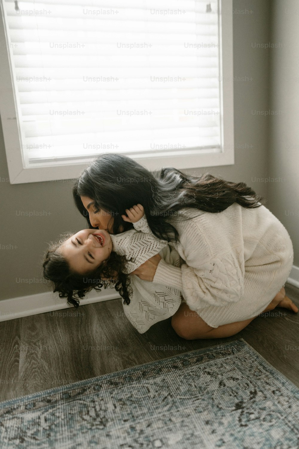 a mother and daughter playing on the floor