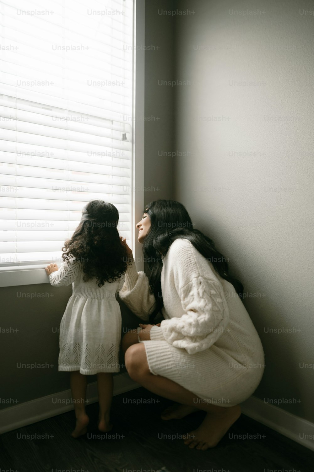 a mother and daughter looking out the window