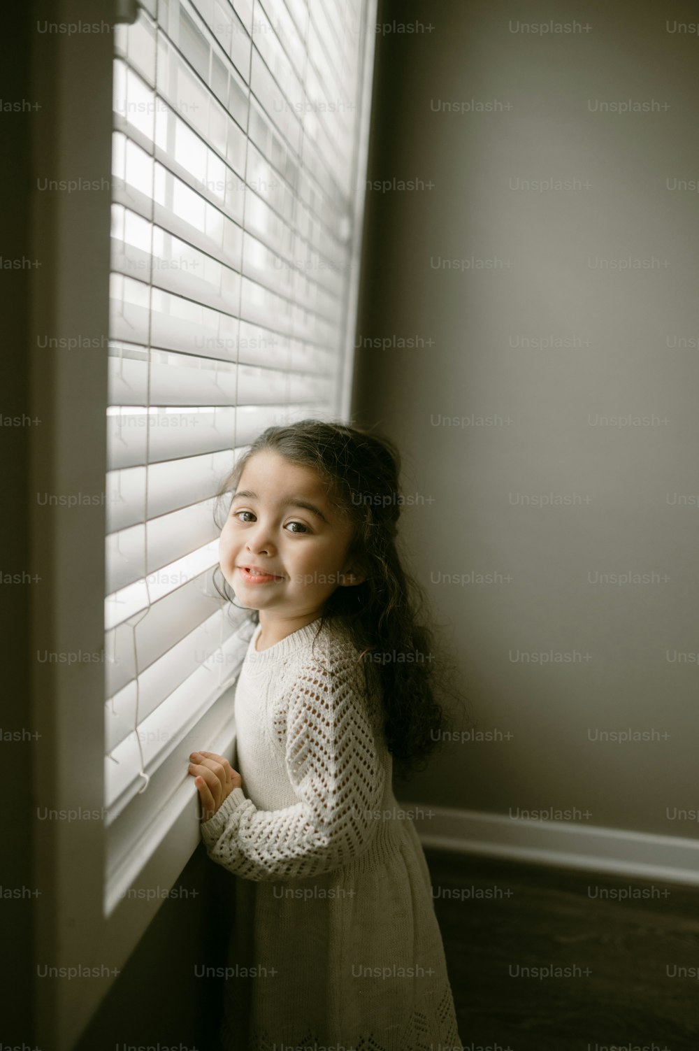 a little girl looking out of a window