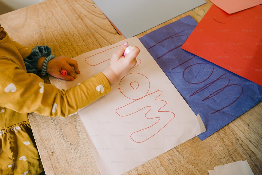 uma criança está escrevendo em um pedaço de papel