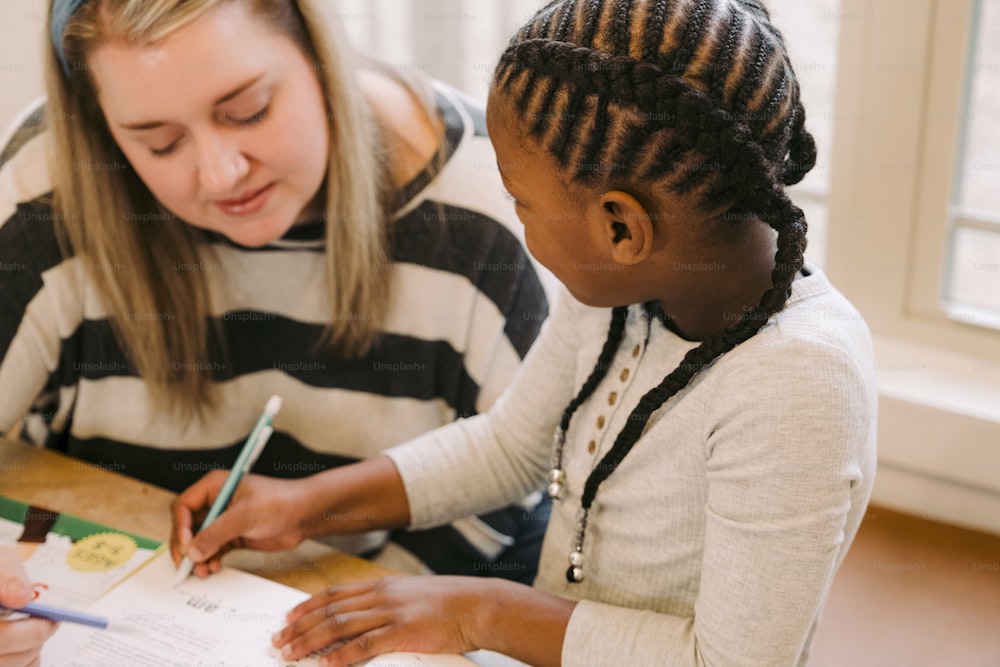 a woman helping a young girl with her homework