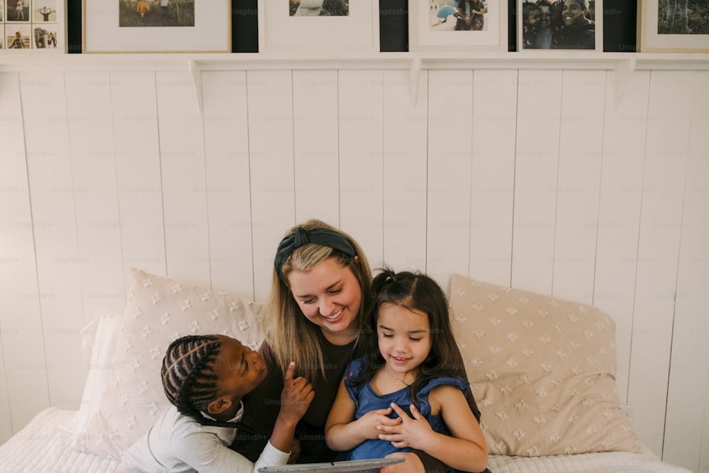 uma mulher e duas crianças sentadas em uma cama