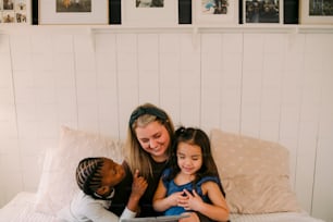 une femme et deux enfants assis sur un lit