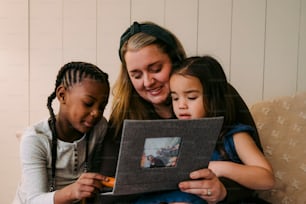 a woman and two children looking at a picture on a tablet