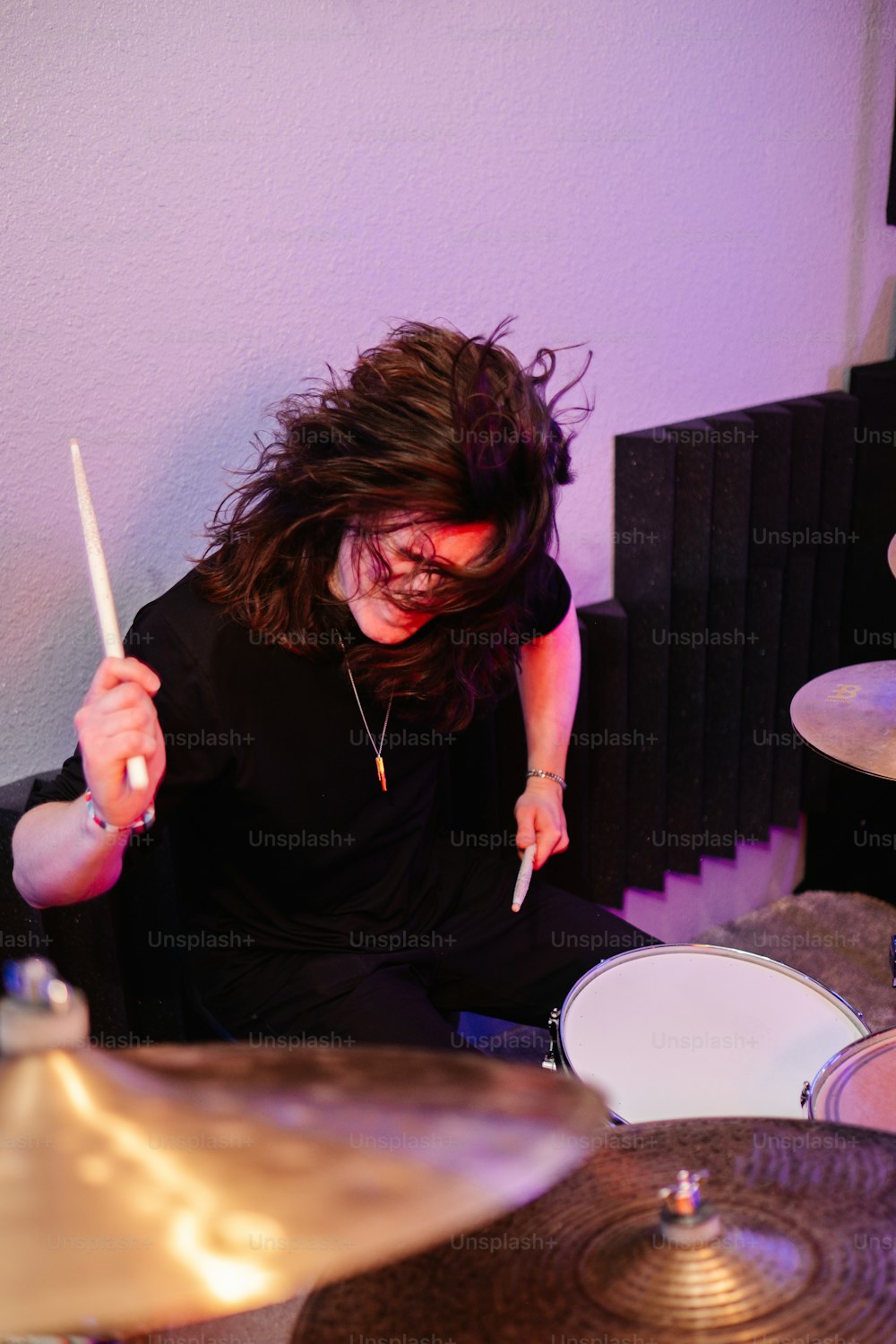 uma mulher está tocando bateria em uma sala