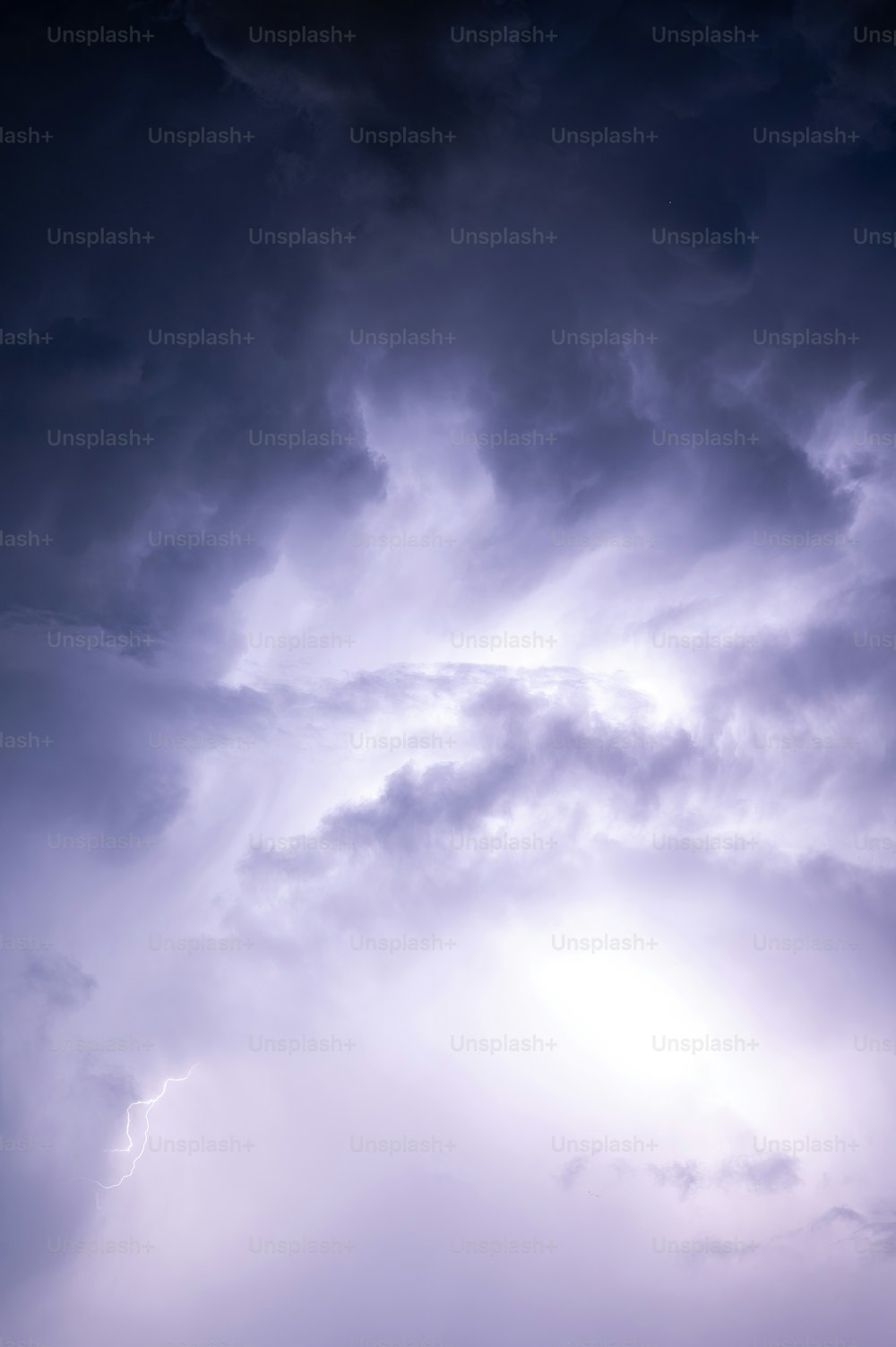 a plane flying through a cloudy blue sky