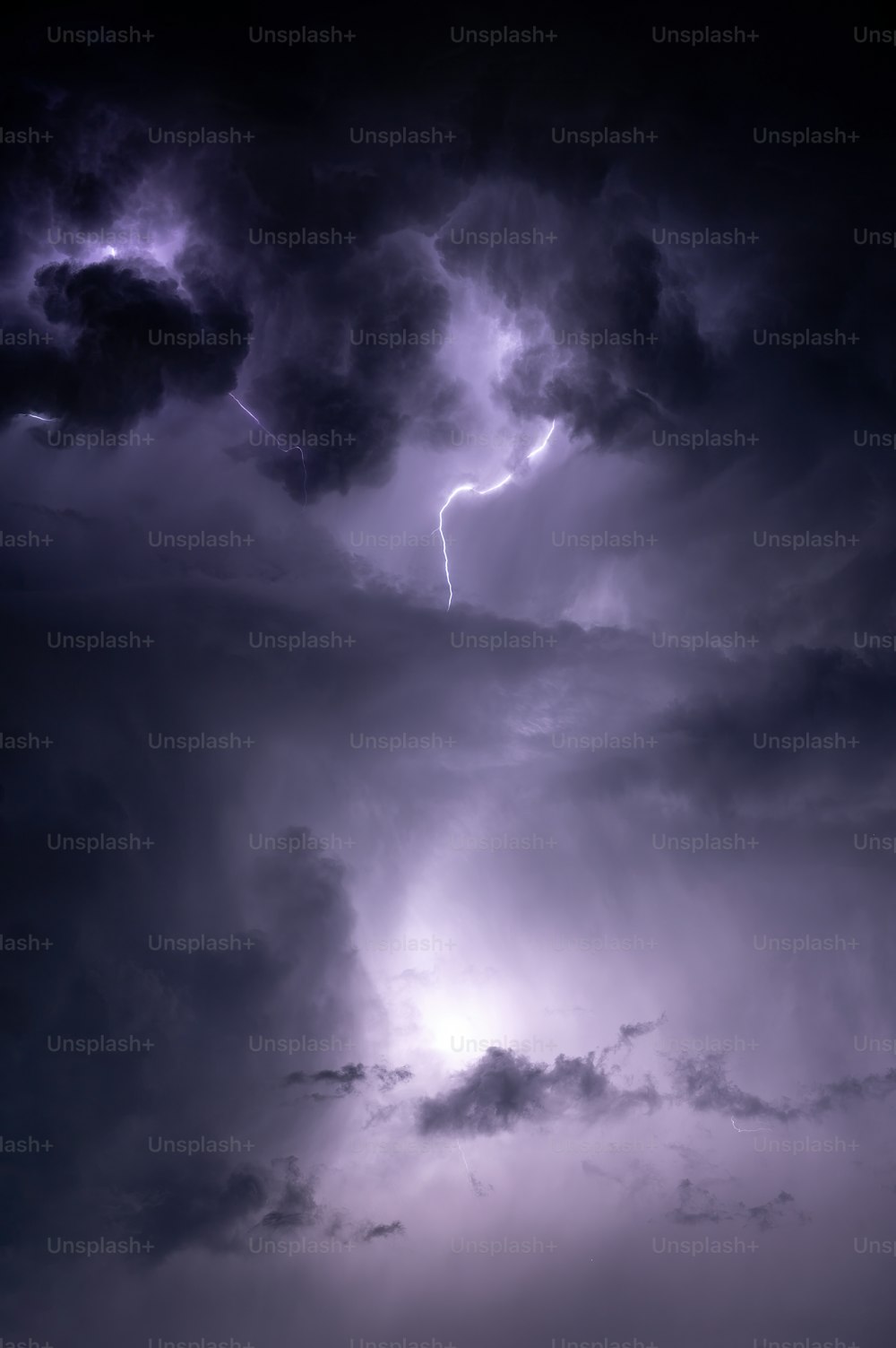 a dark sky with some clouds and a horse in the foreground