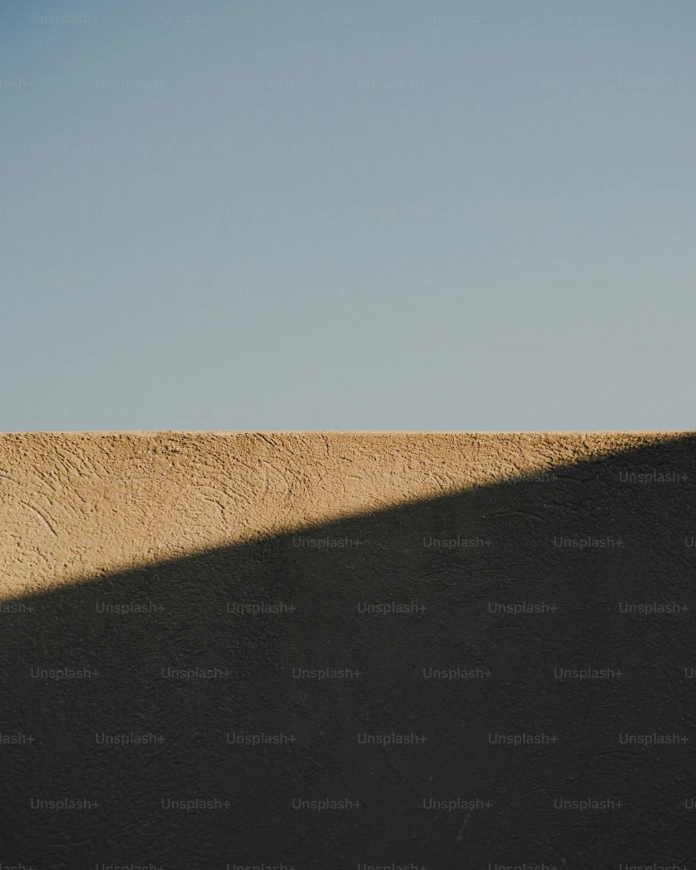 Un homme sur une planche à roulettes au sommet d’un mur de ciment