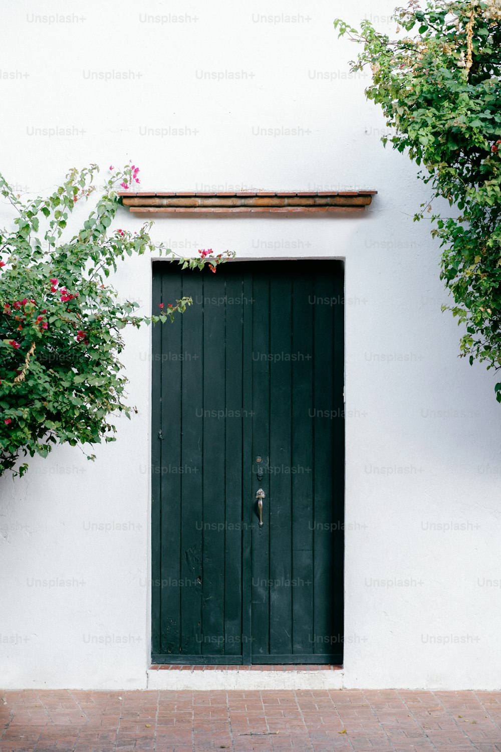 a white building with a green door and window