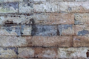 a close up of a brick wall with paint peeling off of it