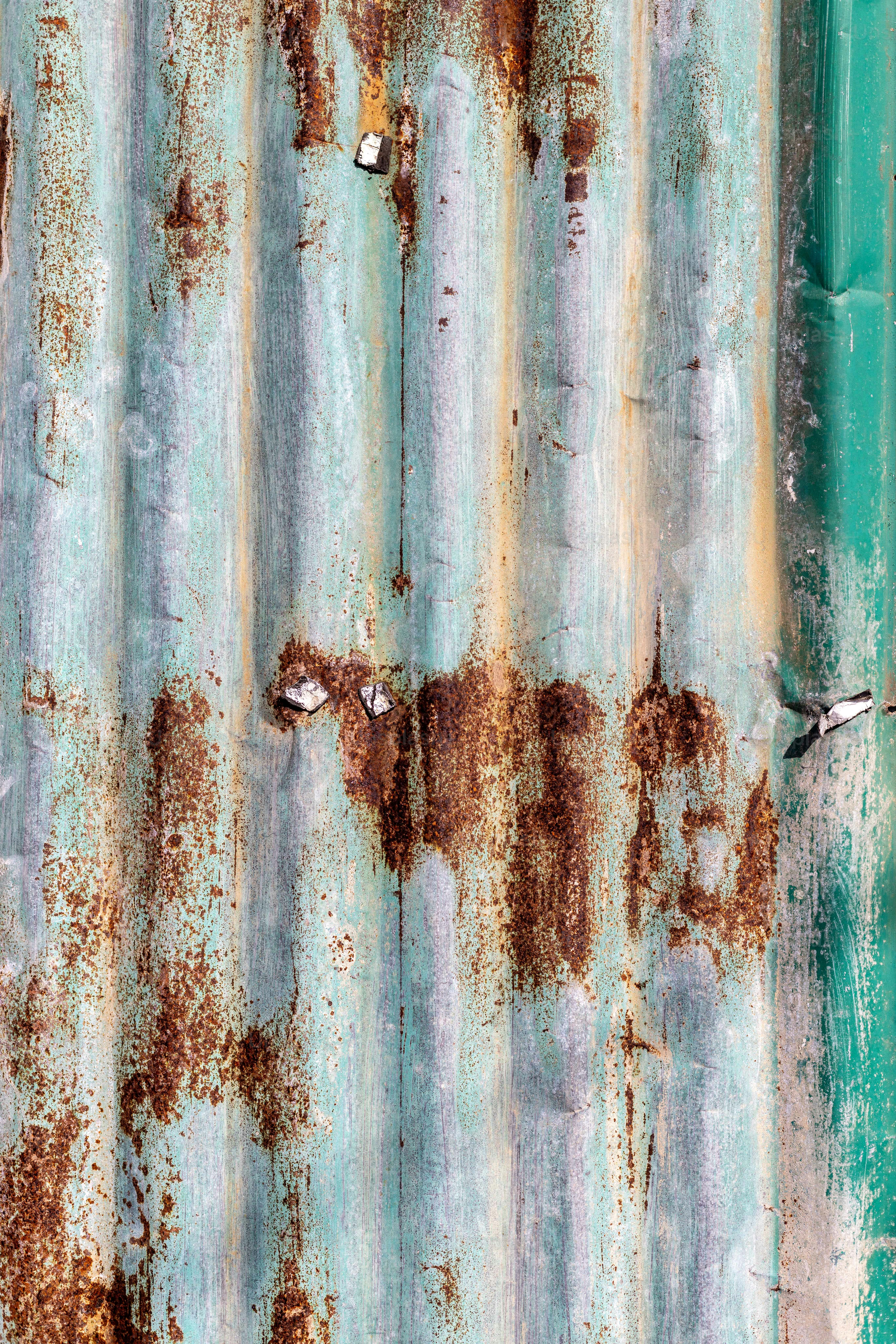 a rusted metal surface with green paint