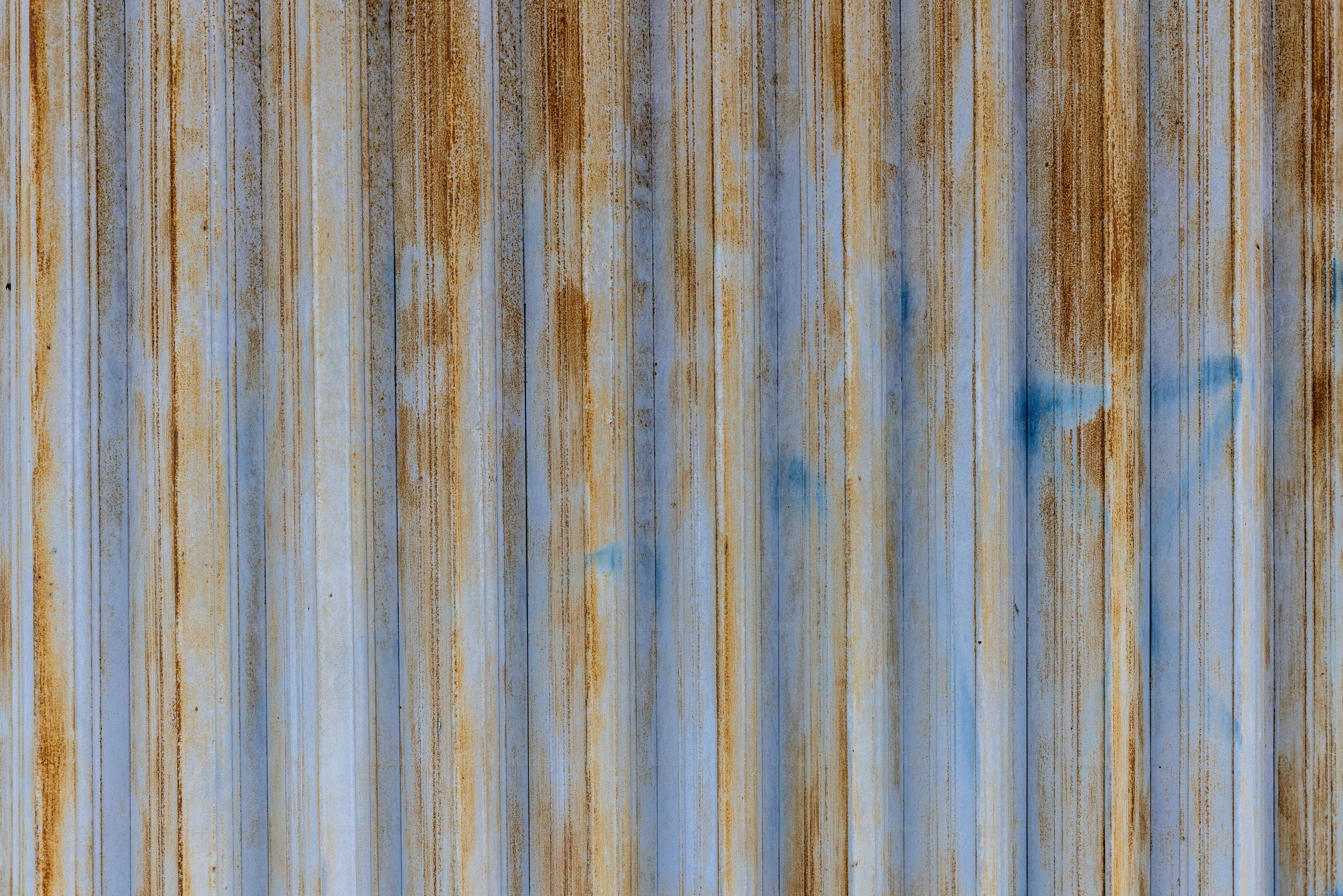 a rusted metal surface with blue paint on it