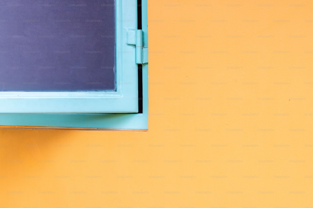 a close up of a window on a yellow wall