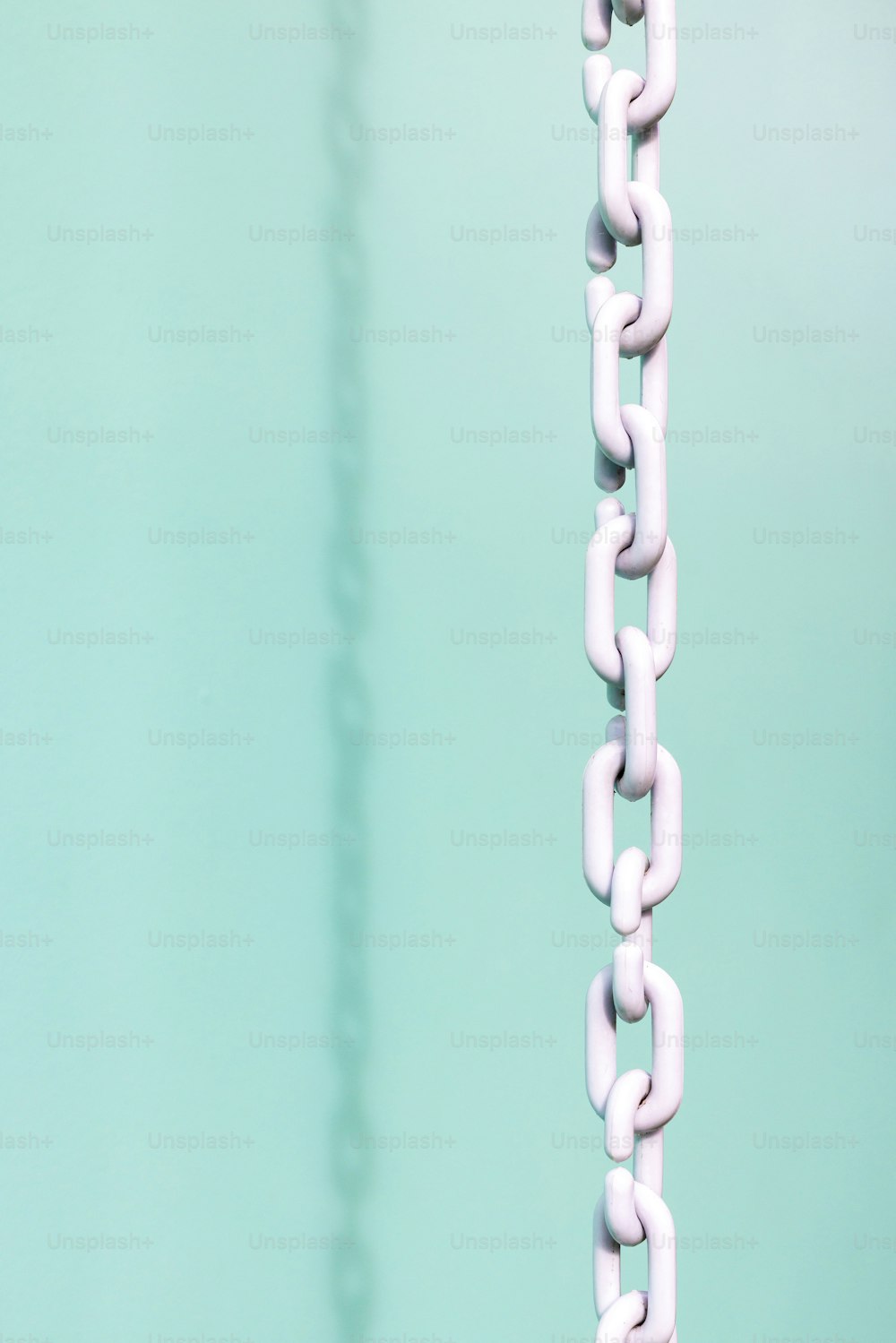 a close up of a white chain hanging from a hook