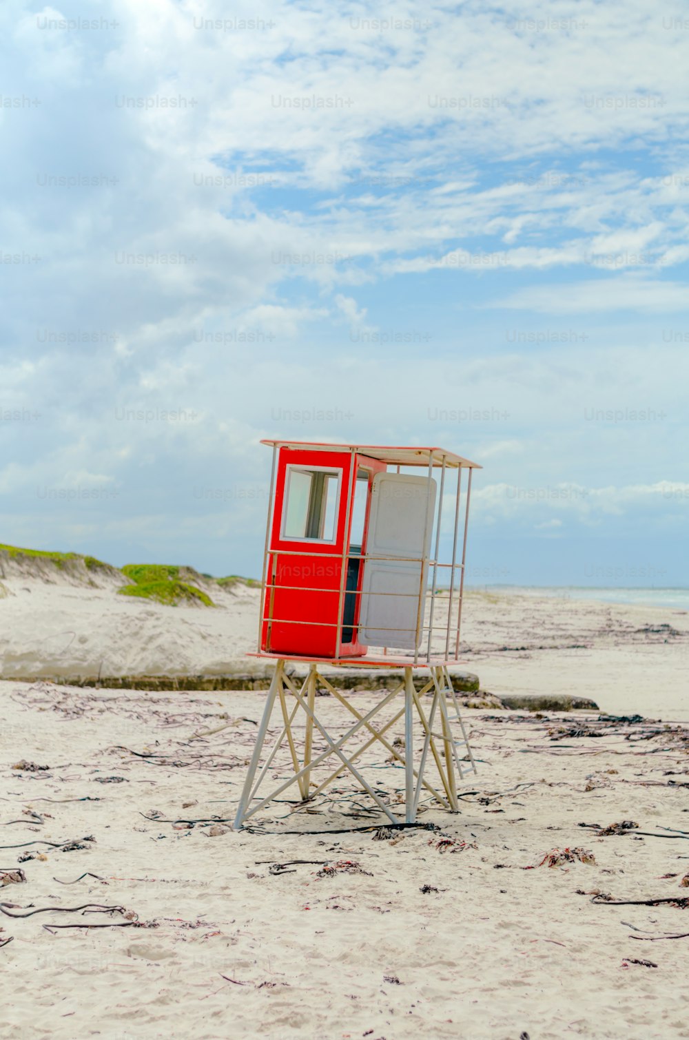 a lifeguard stand on a beach with a blue sky in the background