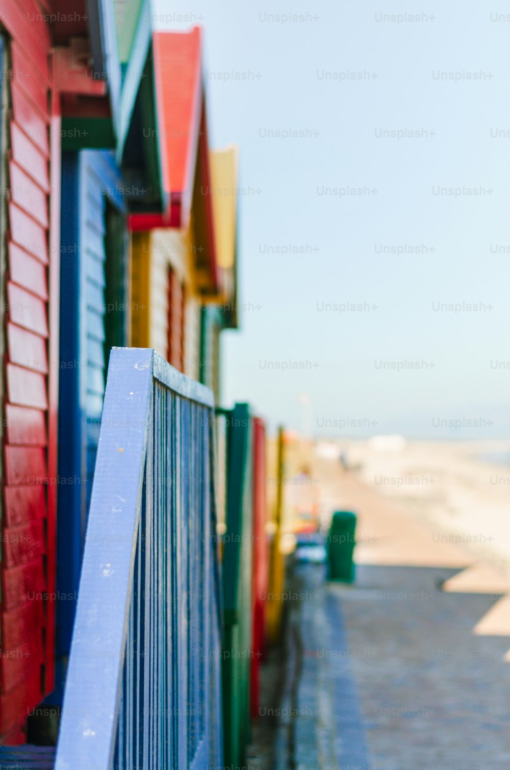 a row of colorful beach huts next to the ocean