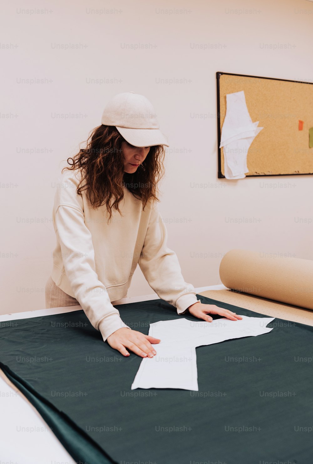 Une femme assise à une table en train de fabriquer un morceau de papier  photo – Vêtements Photo sur Unsplash