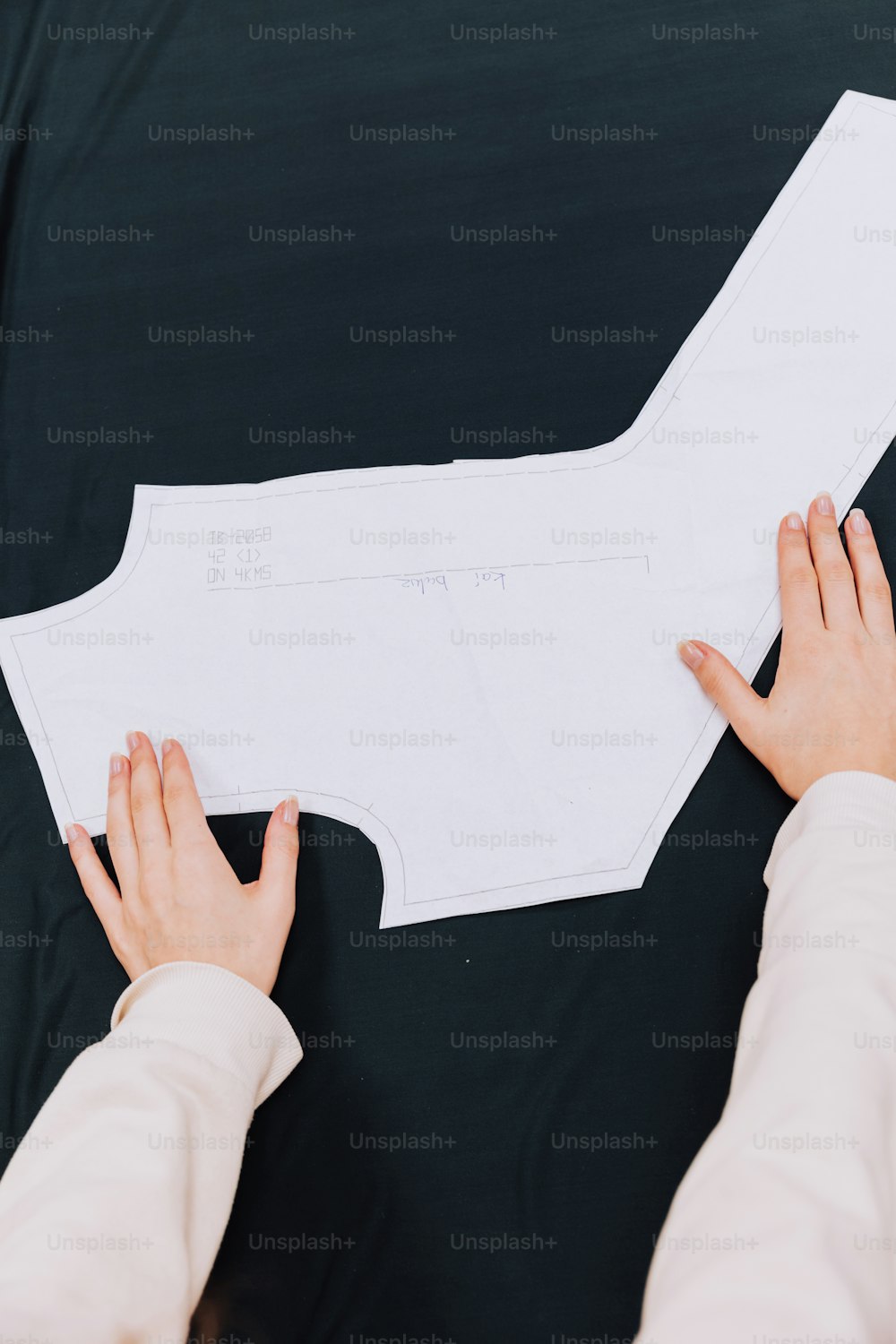 a person cutting out a piece of paper with their hands