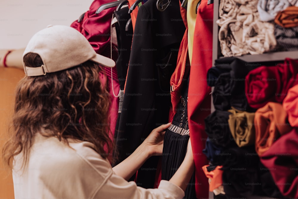 a woman looking at a rack of clothes