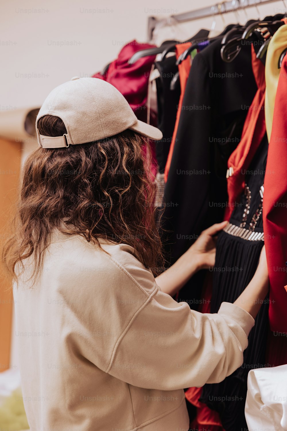 a woman is looking at clothes hanging on a rack