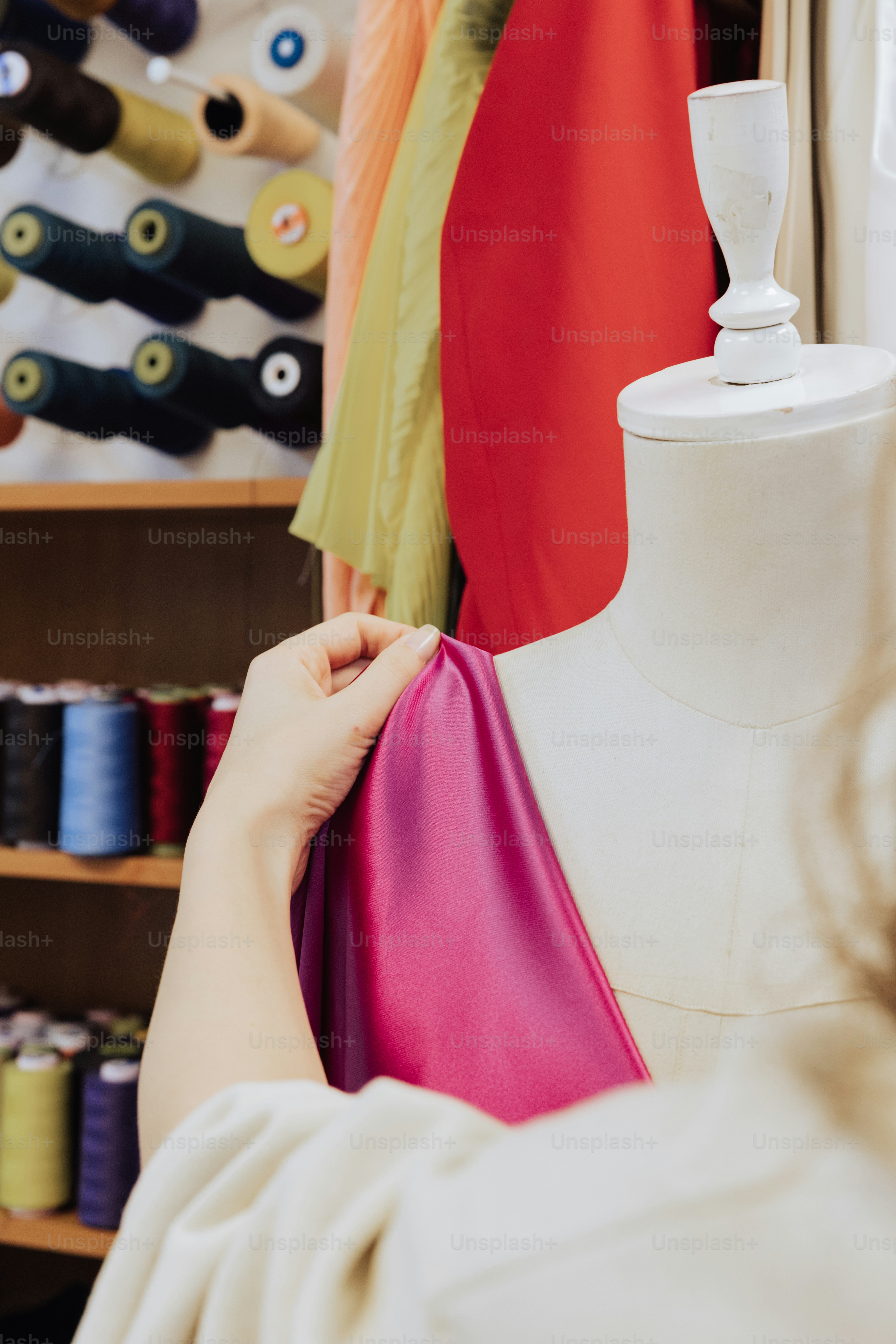 Una mujer trabajando en un vestido en un maniquí