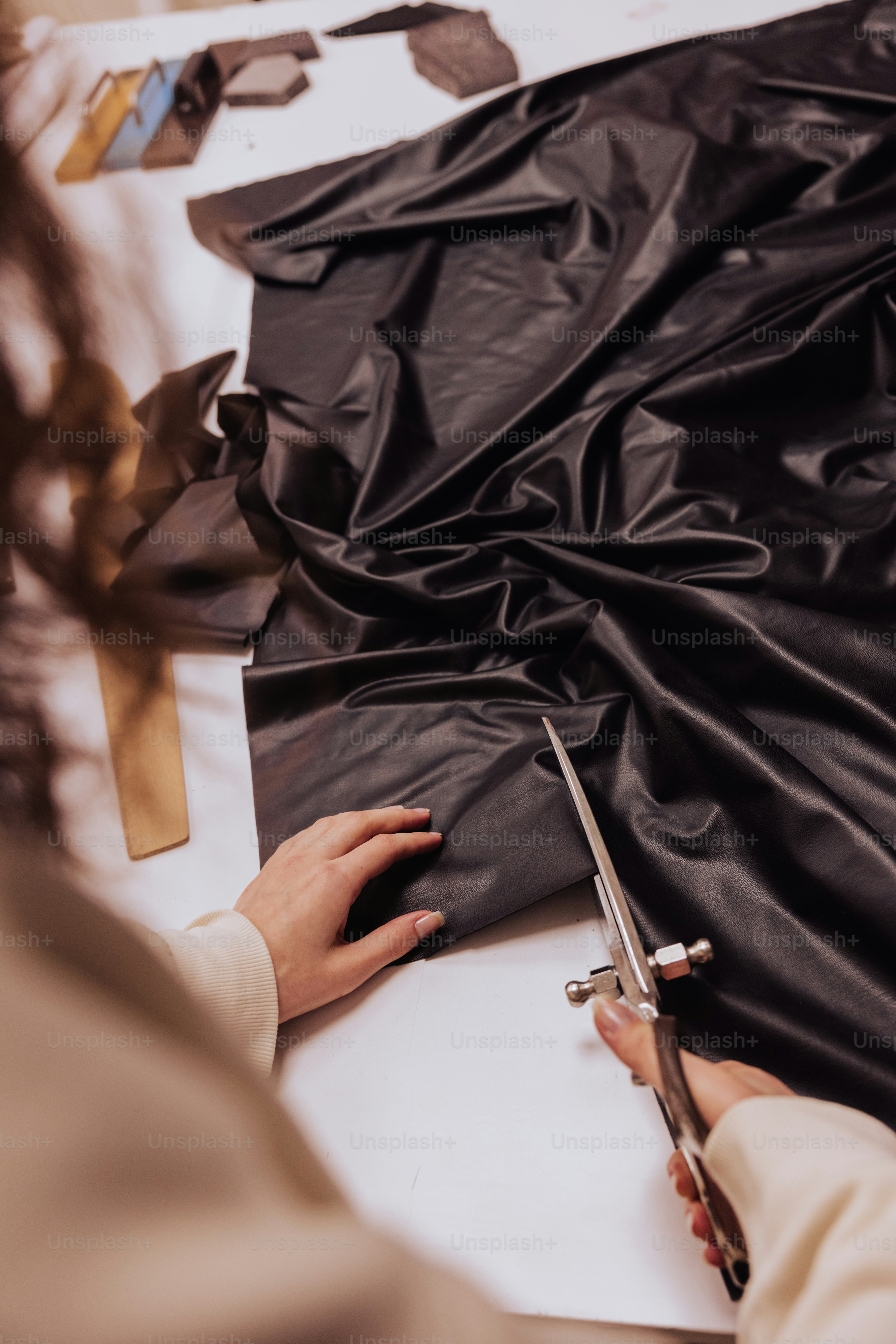 a woman cutting a piece of black vinyl with scissors