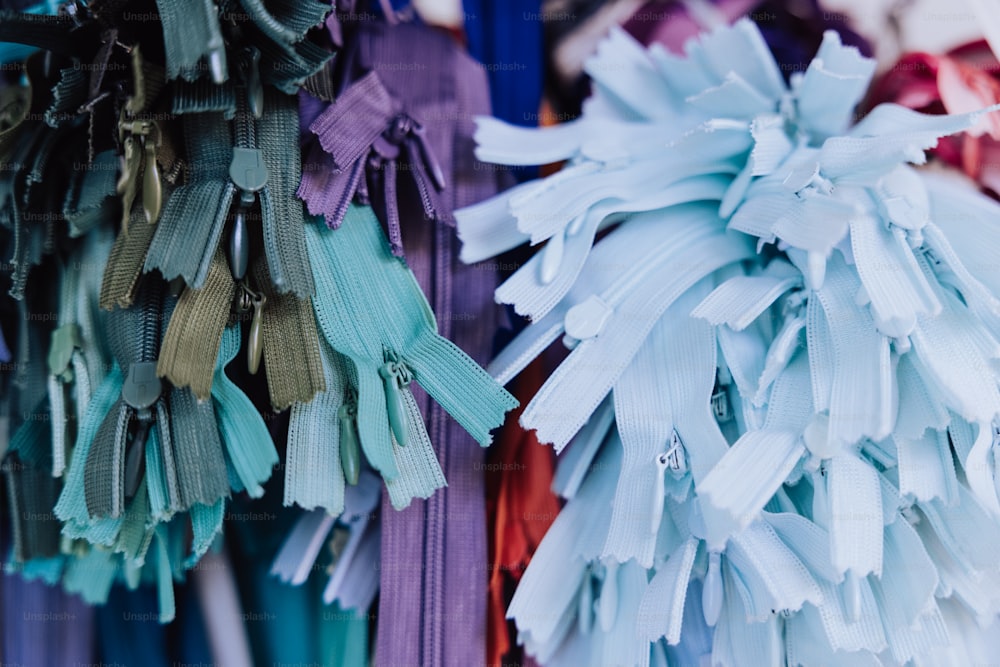 a bunch of different colored ribbons hanging on a wall