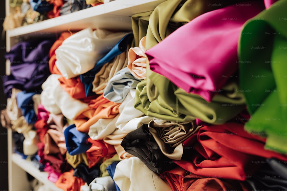 a bunch of different colored clothing on a rack