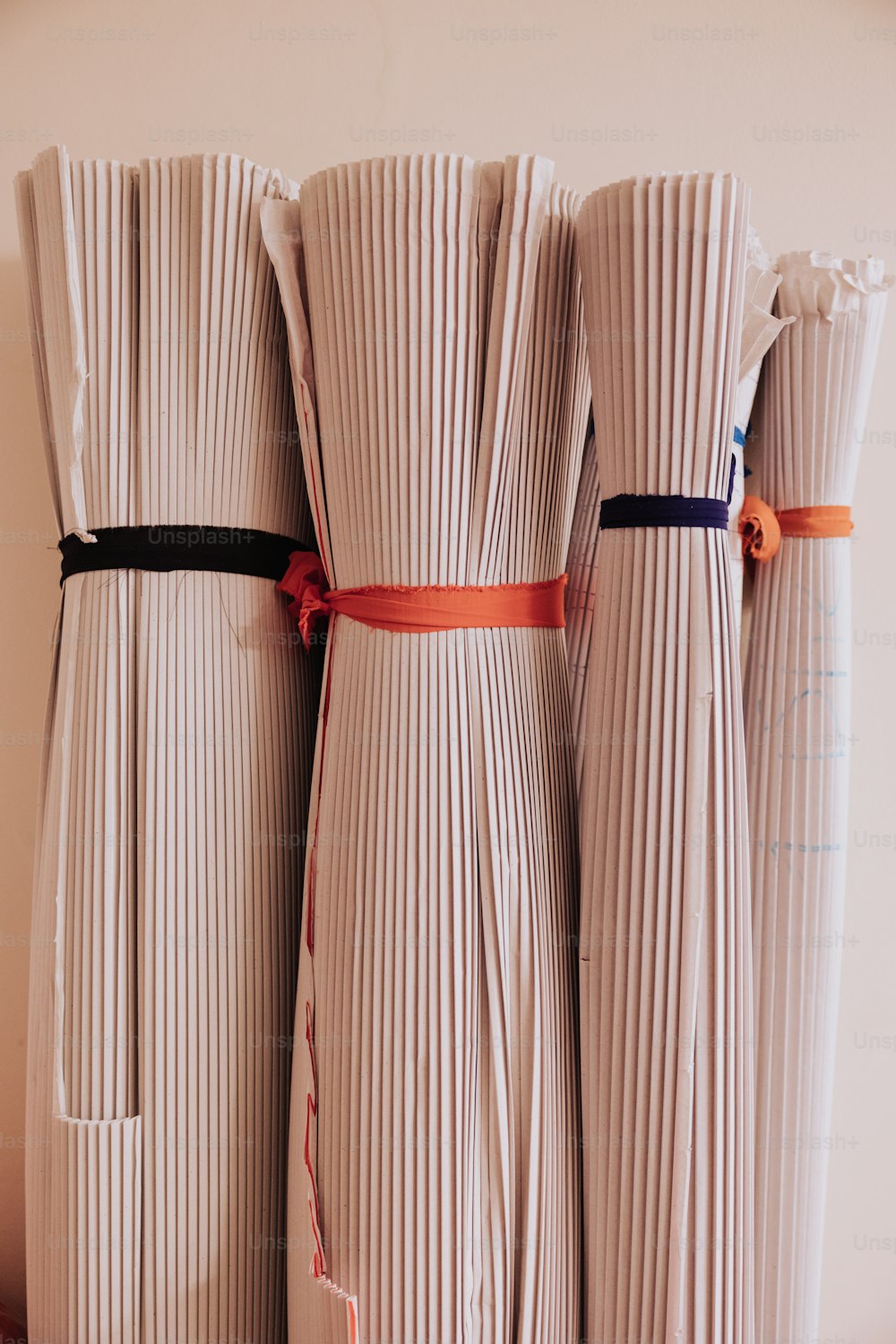 a group of three white vases with ribbons tied around them