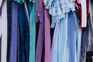 a bunch of different colored ribbons hanging on a wall