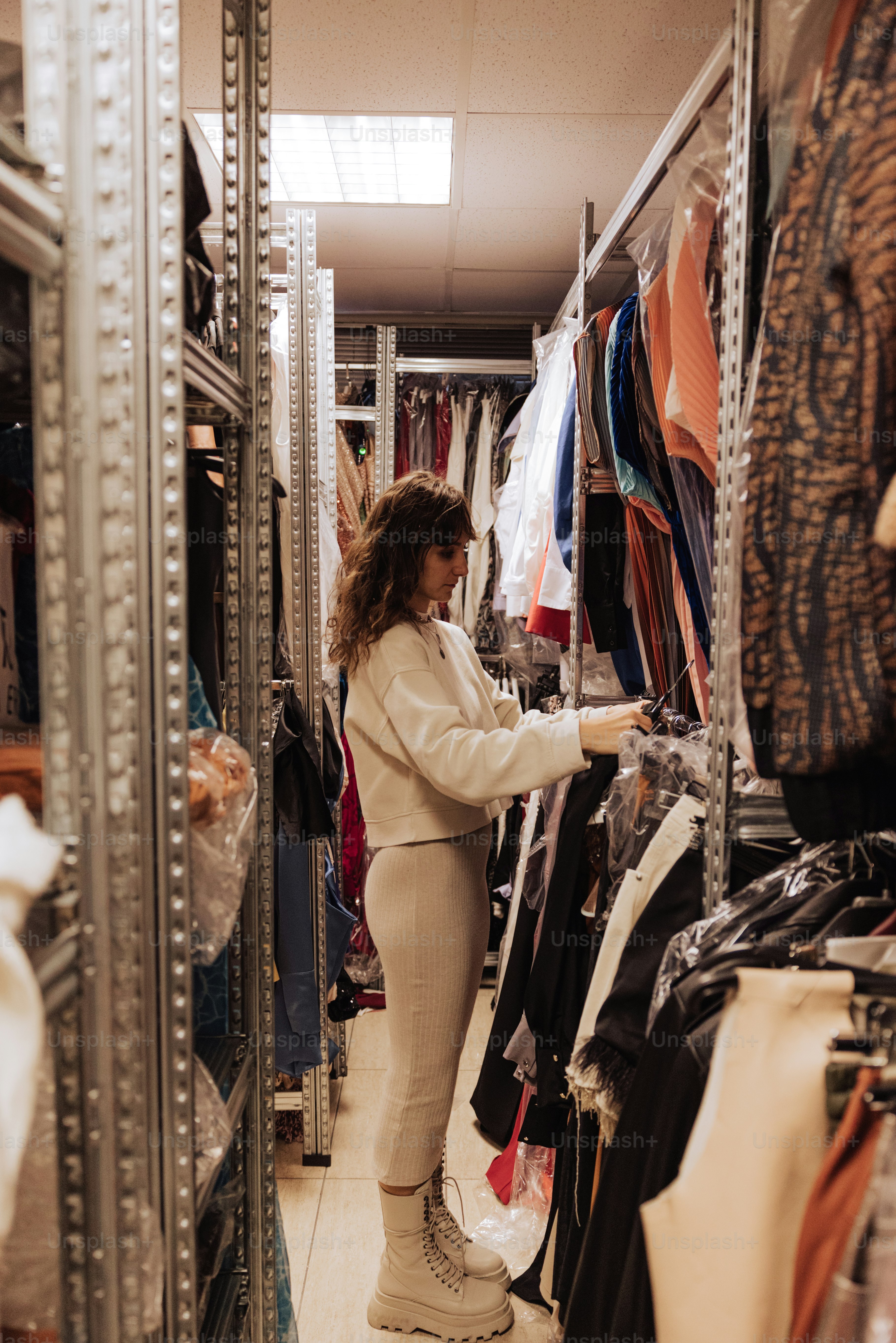 a woman looking at clothes in a closet