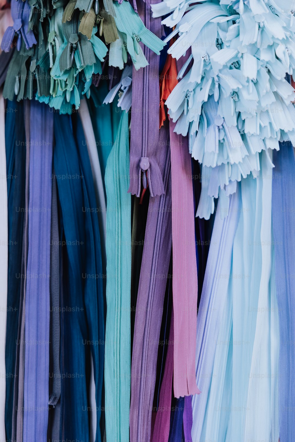 a bunch of different colored ribbons hanging on a wall