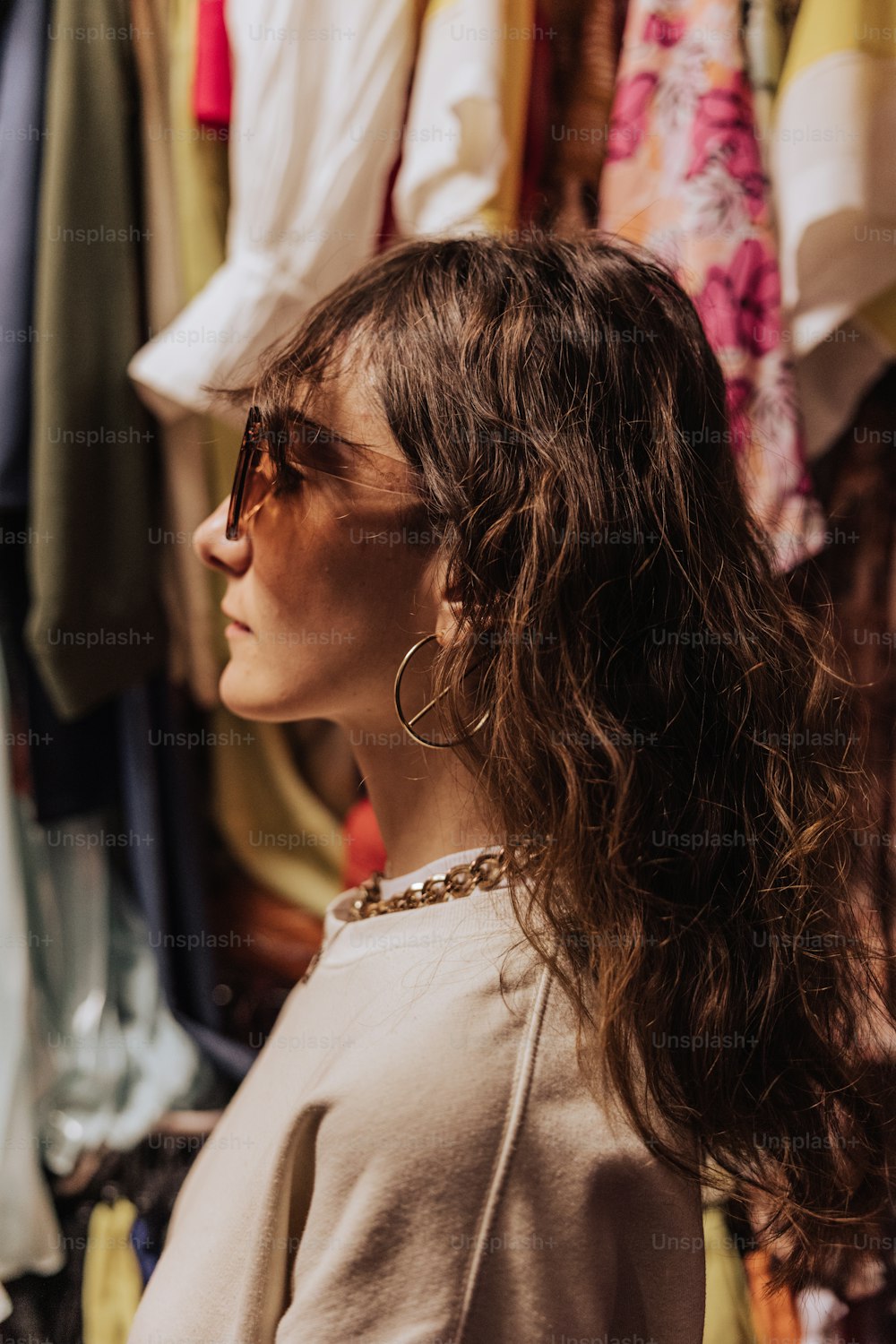 Una mujer parada frente a un estante de ropa