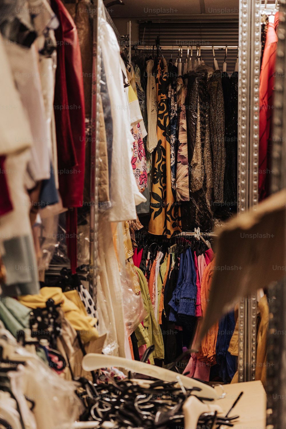 a closet filled with lots of clothes and ties