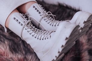 Un par de zapatos blancos sentados encima de un piso cubierto de piel