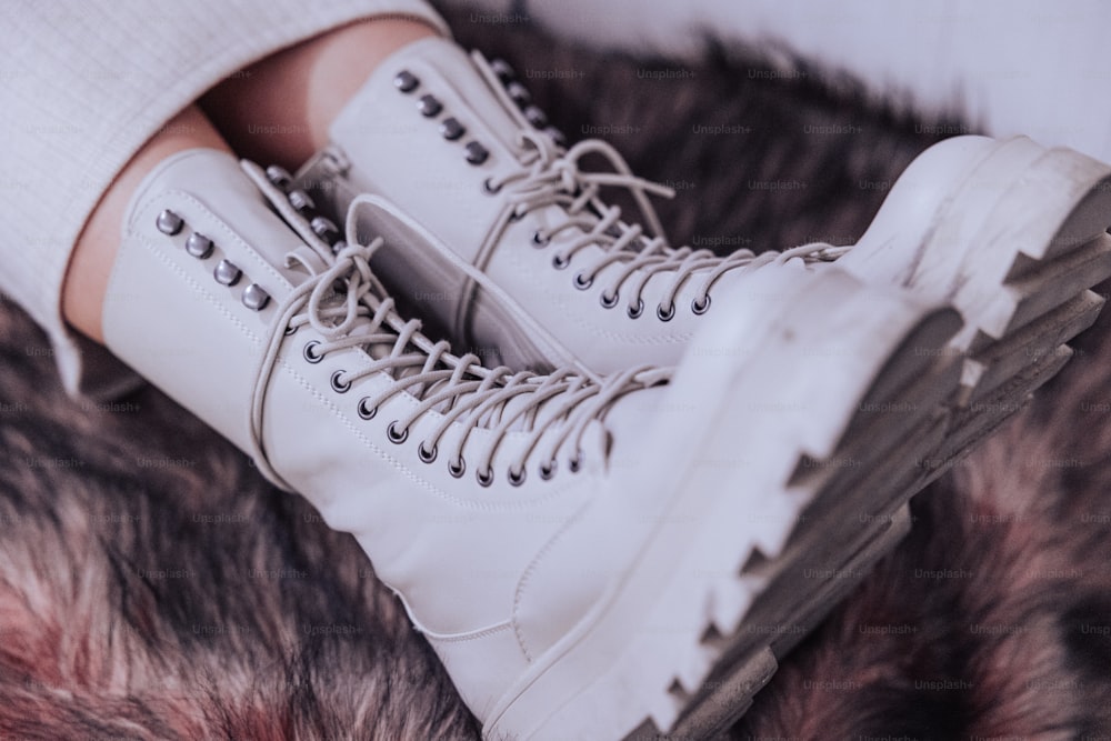 a pair of white shoes sitting on top of a fur covered floor