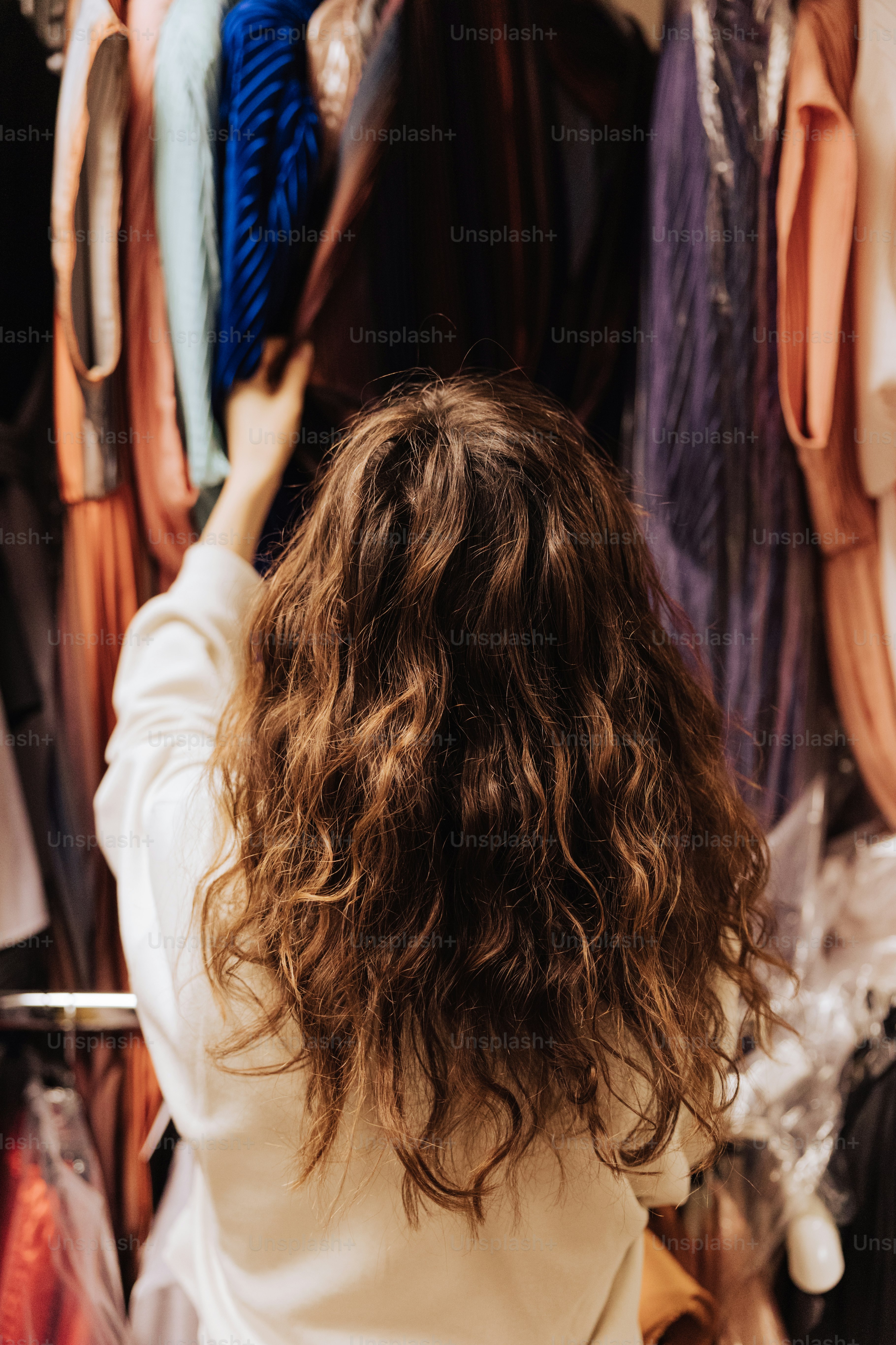 uma mulher olhando para uma prateleira de roupas