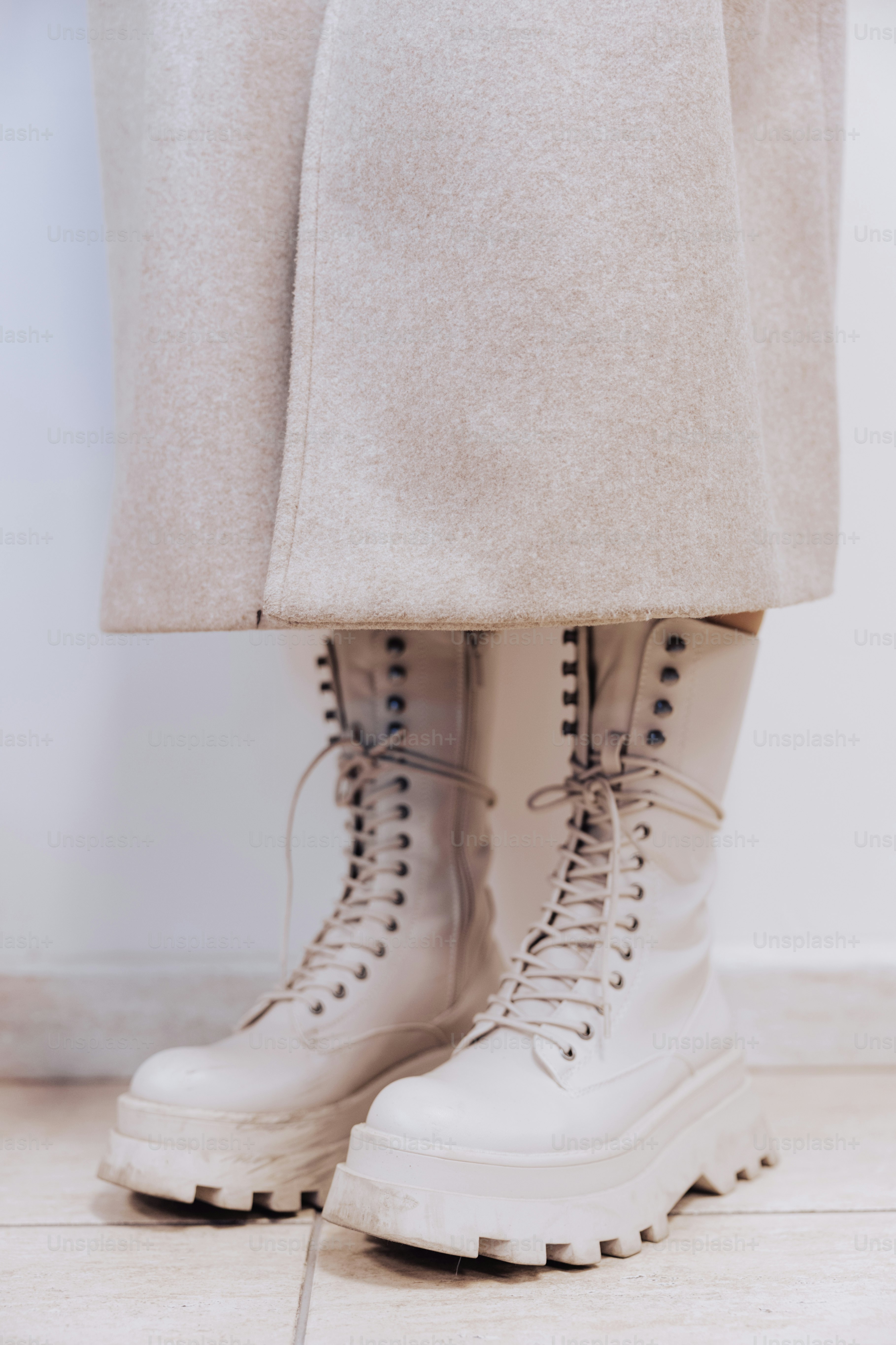 uma pessoa vestindo botas brancas e um casaco branco