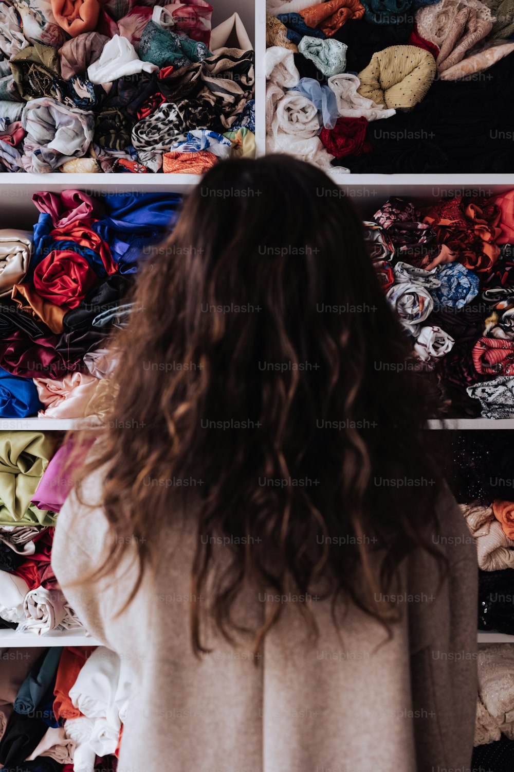 Una donna in piedi davanti a un armadio pieno di vestiti