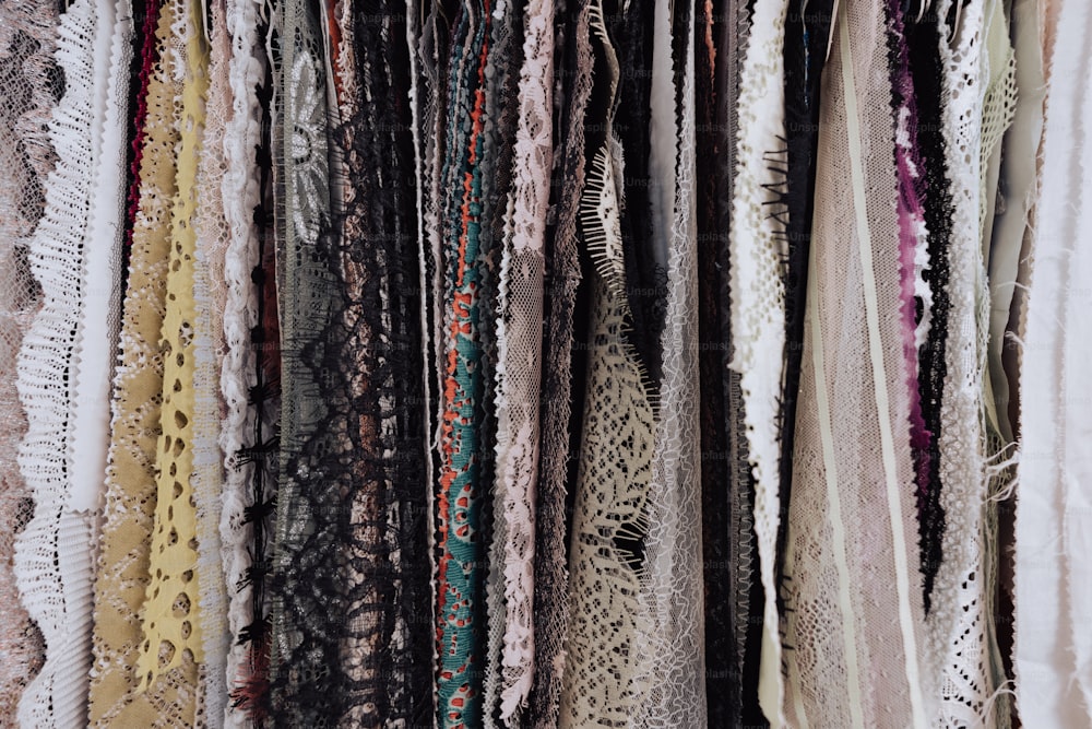 a bunch of scarves are hanging on a rack