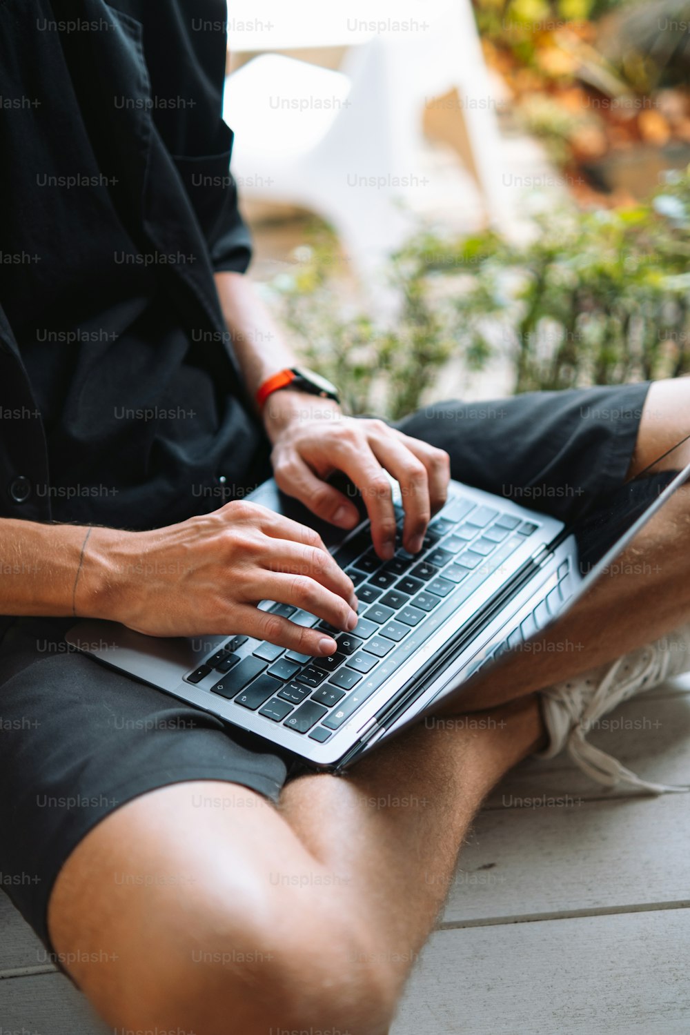 Un uomo seduto a terra con un computer portatile