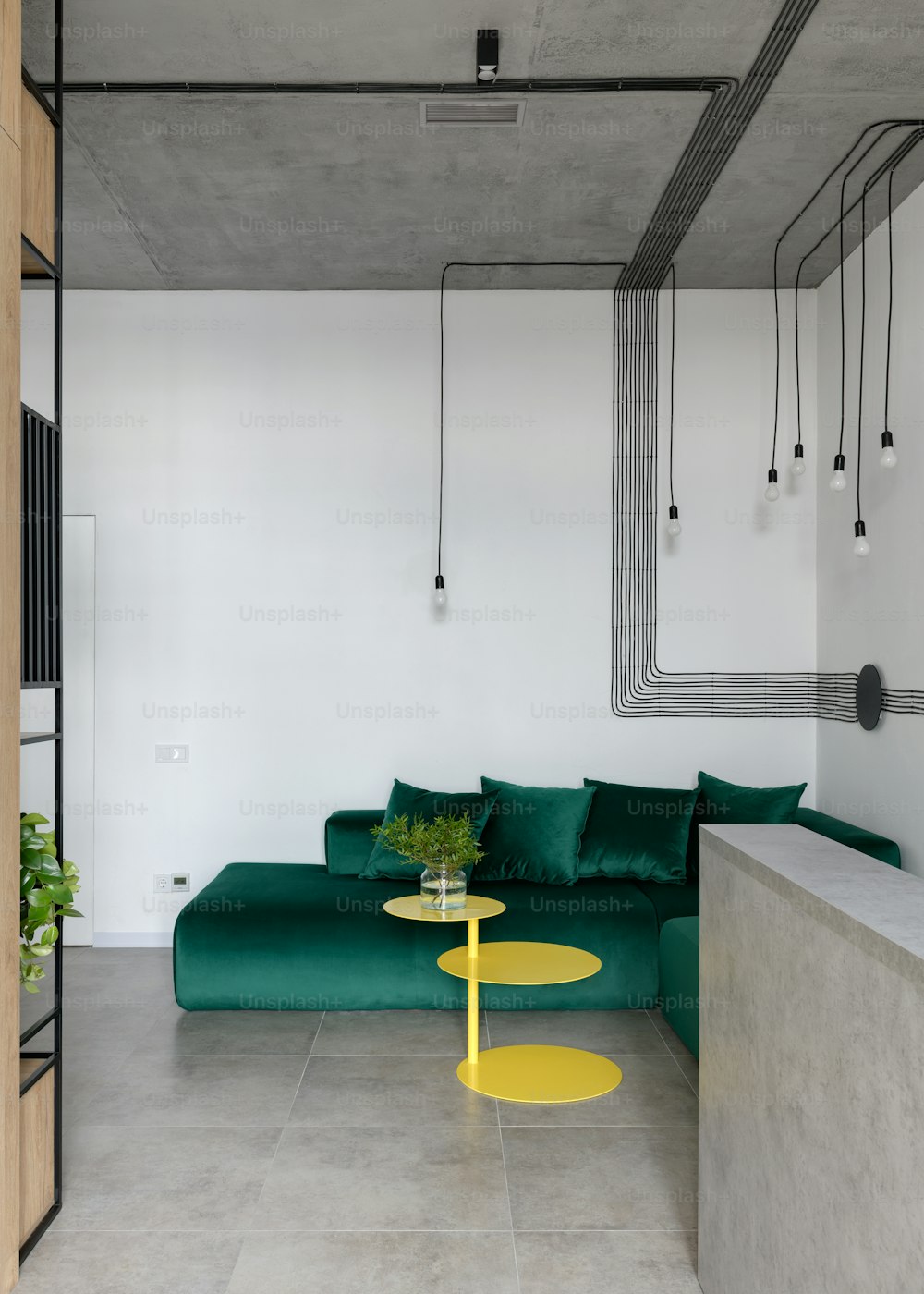 uma sala de estar com um sofá verde e uma mesa amarela