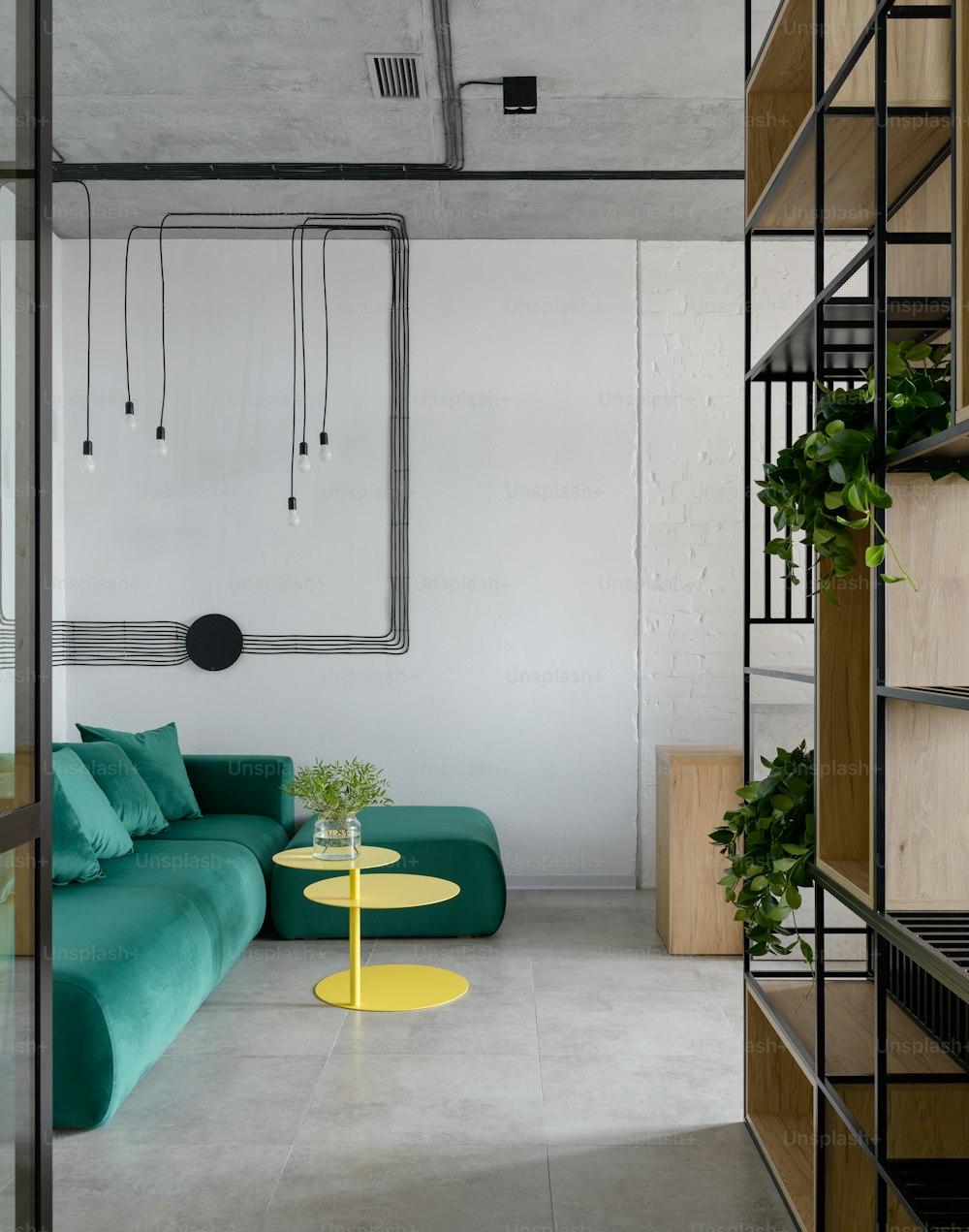uma sala de estar com um sofá verde e uma mesa amarela